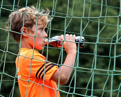 ペットボトルのスポーツドリンクを飲む子供